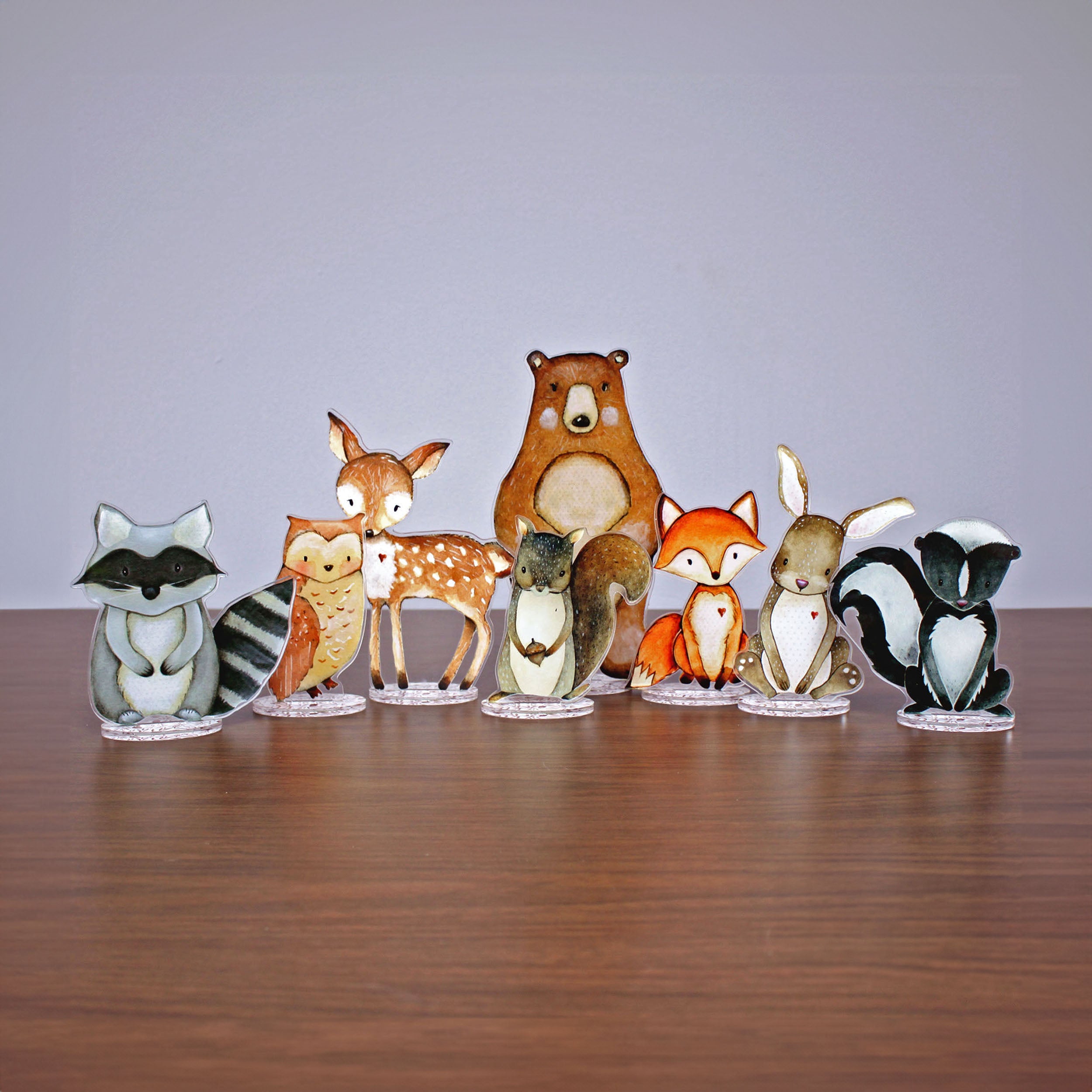 Set of acrylic cutout woodland critters with stands on a table.