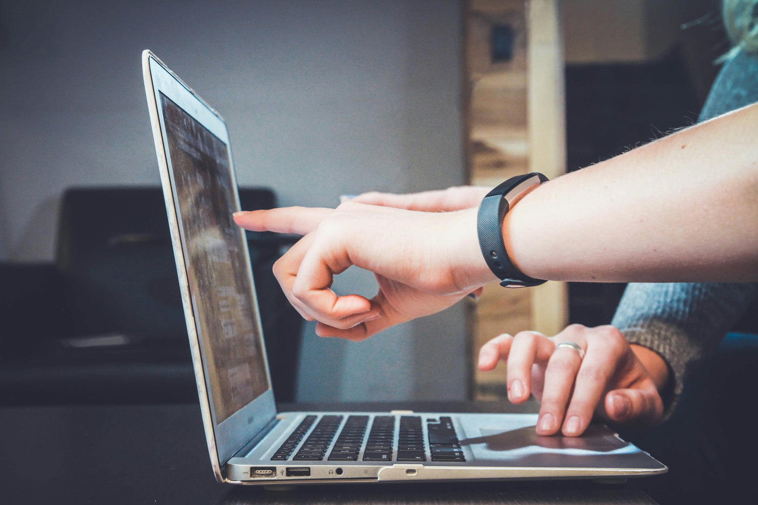 Graphic designers pointing at work on a computer screen.